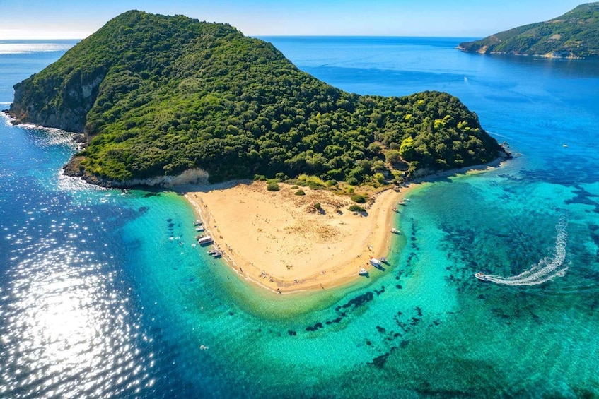 An aerial view of a tropical island with a sandy beach, clear turquoise waters, and lush green vegetation. 3