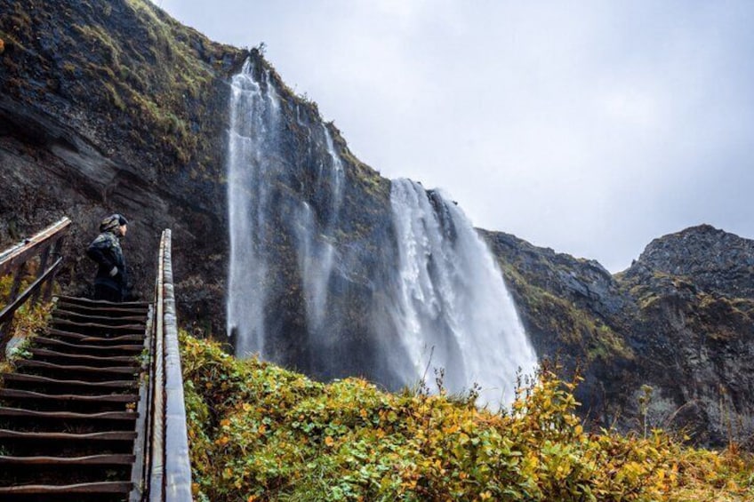 A waterfall, wooden stairs, and a person standing on the stairs. 5