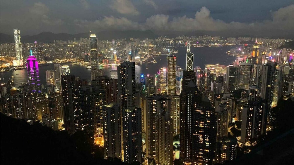 A nighttime cityscape with illuminated skyscrapers and a river. 3