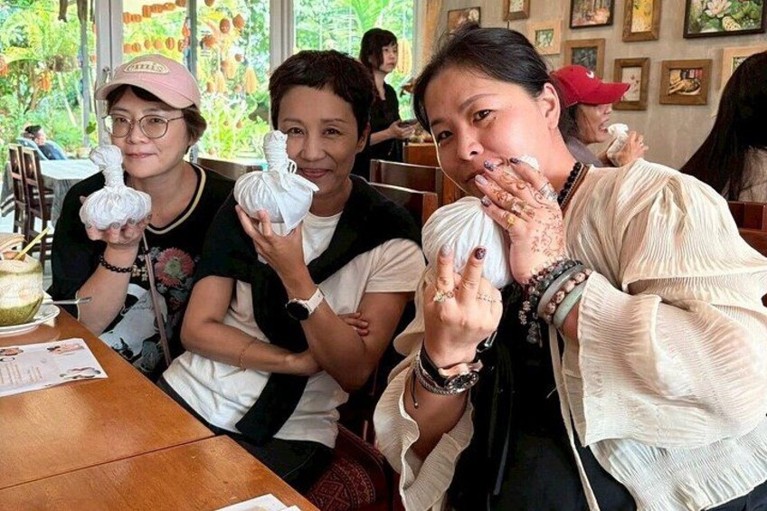 Three people sitting at a table with food items in front of them. 1