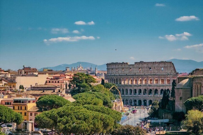 El Coliseo de Roma rodeado de árboles y edificios. 1