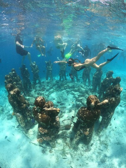 Divers swimming around underwater statues. 2