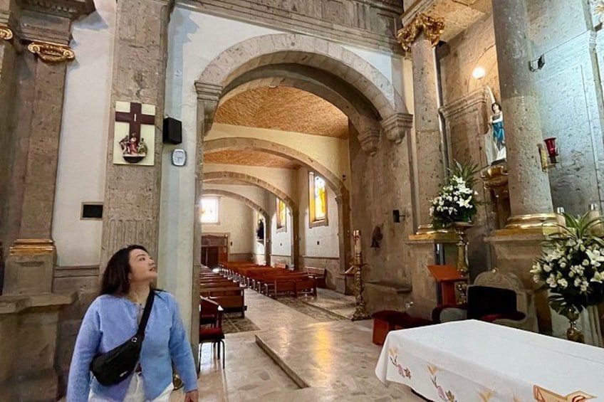 L’intérieur d’une église, avec ses voûtes en arc, ses rangées de bancs et ses statues religieuses. 5