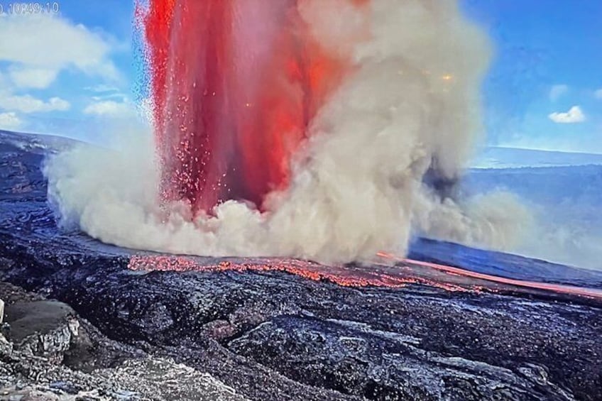 A volcanic eruption with lava flowing and steam rising. 1