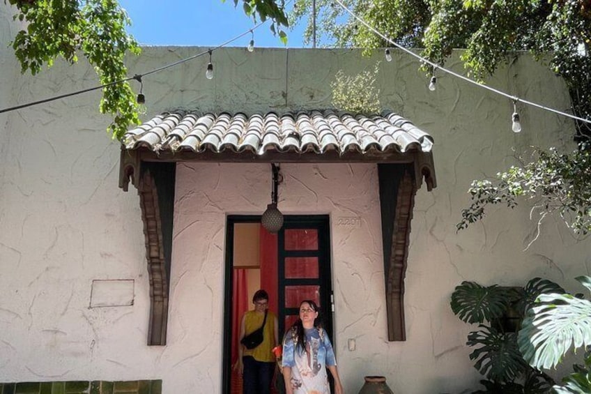 Un bâtiment doté d’un toit en tuiles et d’une porte, entouré de verdure. 3