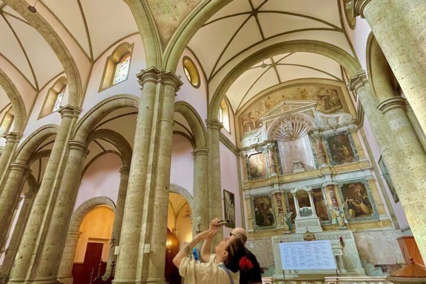 L’intérieur d’une cathédrale, avec de hauts plafonds en arc de cercle, de grandes colonnes et des œuvres d’art à caractère religieux. 5