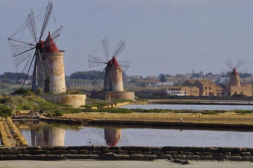 Windmills, a body of water, and traditional buildings. 1
