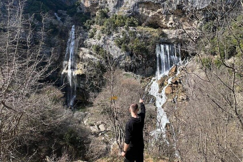 Una cascata con diverse gradinate, immersa in un terreno roccioso e scarsamente vegetato. 5