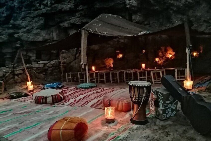Interior de una cueva con un pozo de fuego, tambores y una guitarra. 2