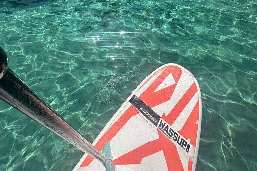 Una tabla de paddleboard con diseño rojo y blanco en aguas cristalinas. 4