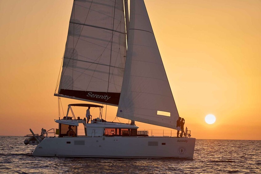 A sailboat named Serenity sailing on the water during sunset. 1