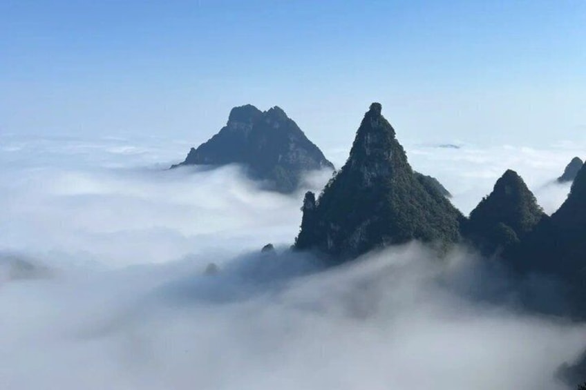 A mountain range with peaks above a sea of clouds. 5