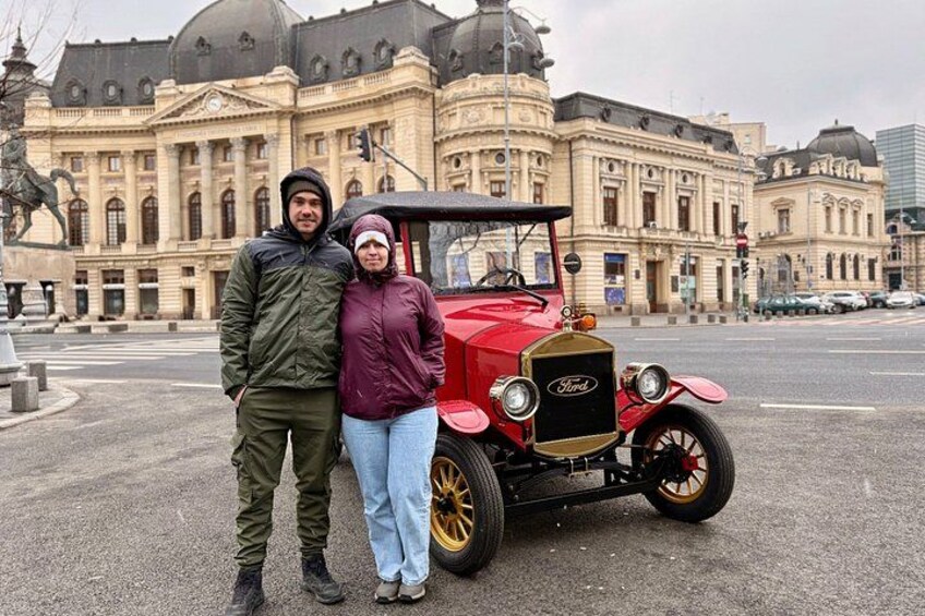 Un coche Ford Modelo T antiguo estacionado frente a un edificio histórico de arquitectura abovedada. 3