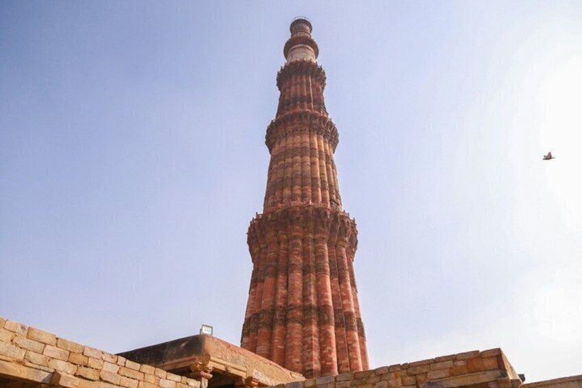 Een hoge, rode bakstenen minaret met een spiraaltrap, voor een heldere lucht. 3