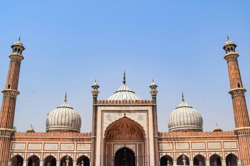 Een historisch gebouw met meerdere koepels en minaretten. 1