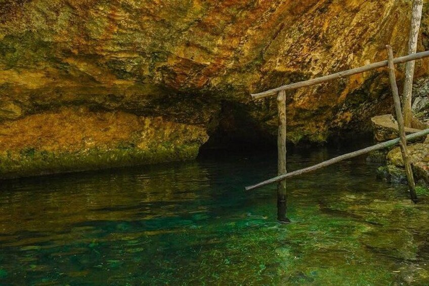 Eine Höhle mit klarem Wasser und Holzbauten. 3