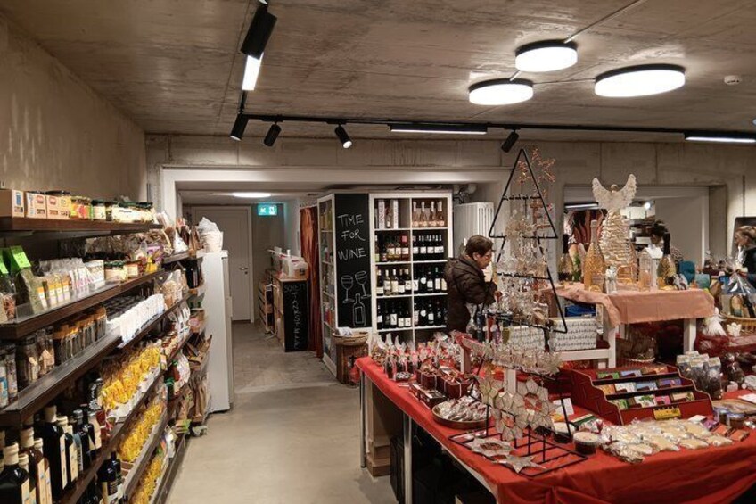 A market with shelves of goods, a display table with items, and a person in the background. 5