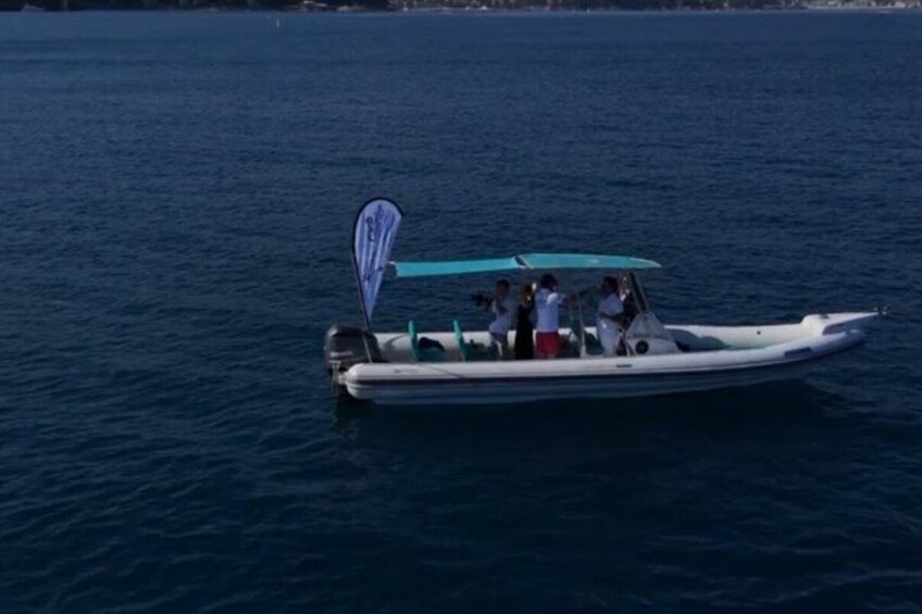 A small motorboat with a canopy on a calm body of water. 2