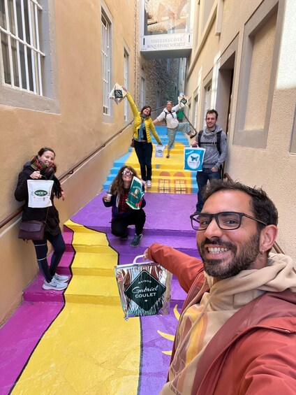 A group of people on a colorful staircase in a narrow alleyway with buildings on either side. 3