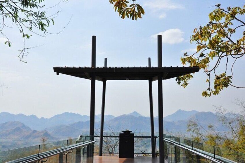 Een prieel met glazen balustrade, met uitzicht op een bergachtig landschap. 4