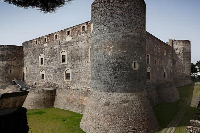 Ett medeltida slott med ett stort, runt torn, en befäst mur och en gräsbevuxen innergård. 3