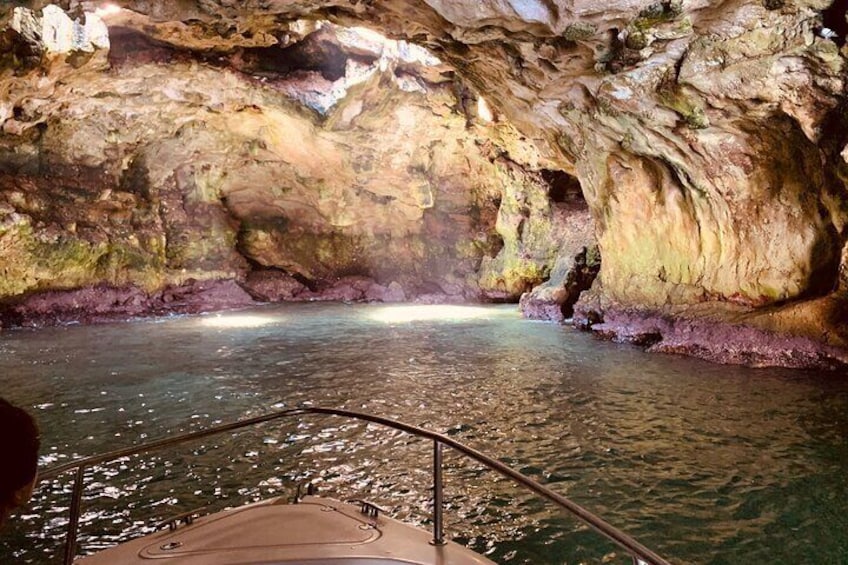 Ein Boot auf einem Fluss in einer Höhle mit felsigen Wänden und einem Geländer. 4
