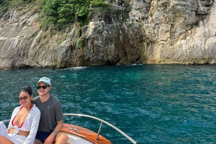 A boat on turquoise water with rocky cliffs in the background. 4