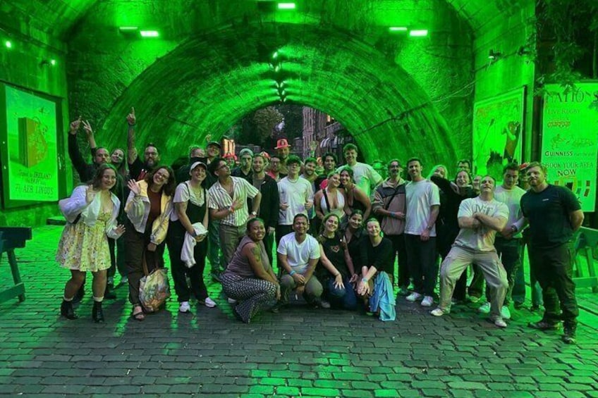 A group of people posing in a tunnel with green lighting. 3