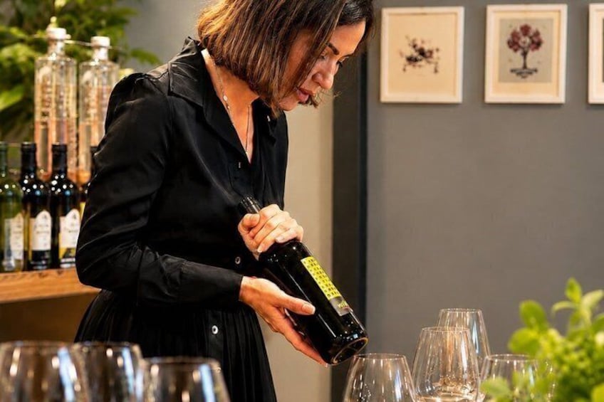 En person hælder vin i glas. 4