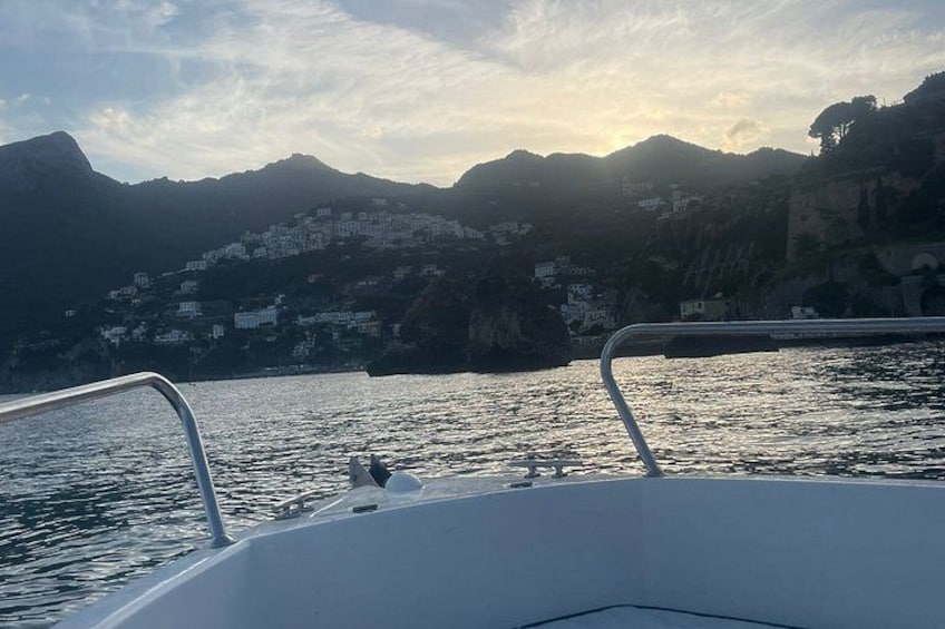 A boat on calm water with a mountainous coastline in the background. 4