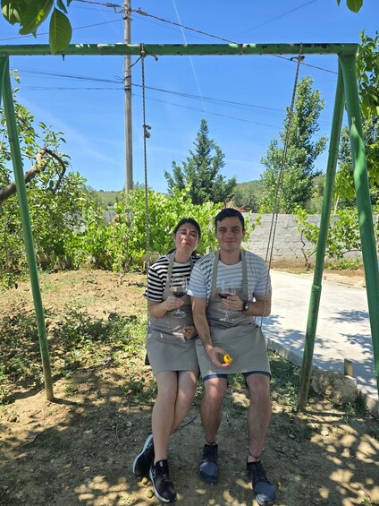 Two people on a swing set in a garden with greenery and a clear sky. 4
