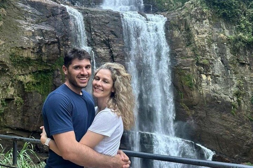 A couple standing in front of a waterfall. 4