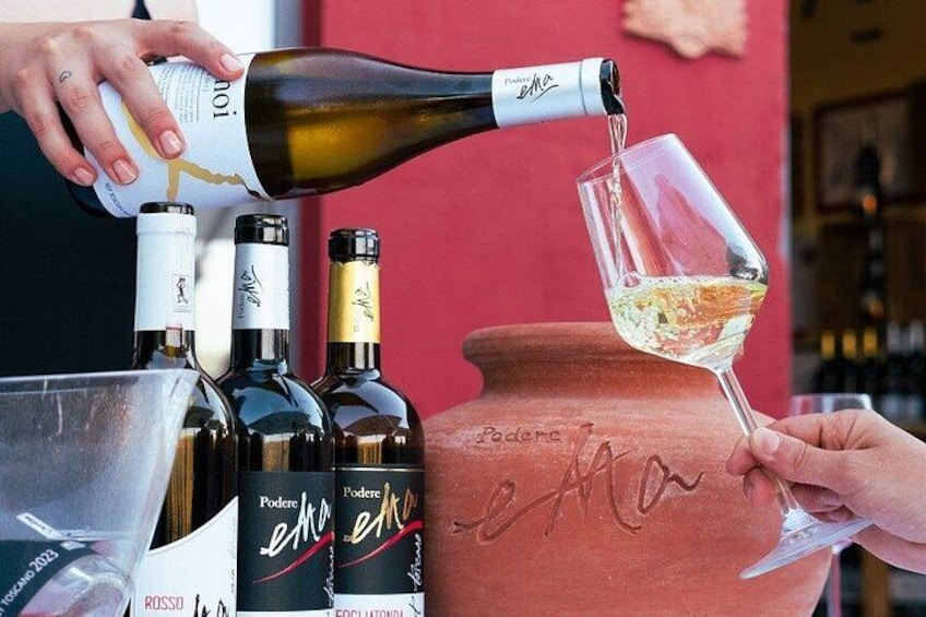 A person pouring wine from a bottle into a glass. There are multiple wine bottles and a clay pot with the word 'Podere' on it. 4