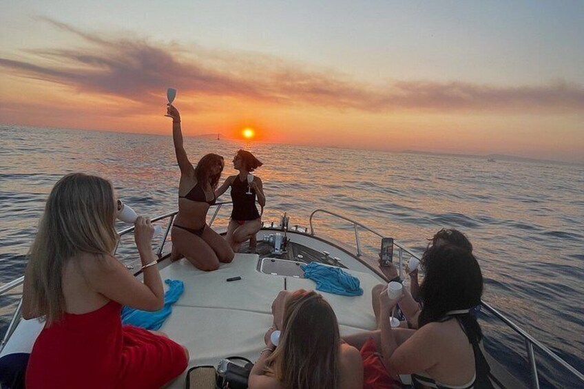 A sunset over the ocean with people on a boat. 1