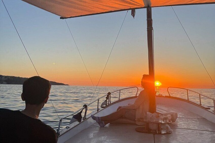 A sunset on a calm sea with a sailboat. 3