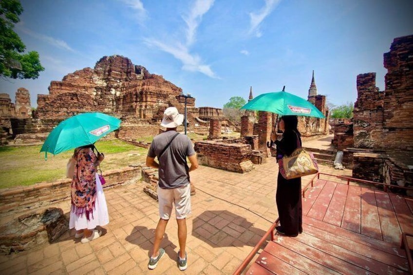 Tourists at an ancient temple with ruins and a clear sky. 5