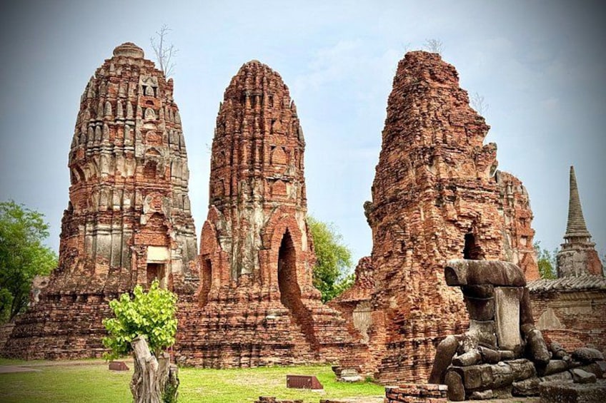 Ancient brick structures with multiple tiers and a smaller building with a pointed roof. 2