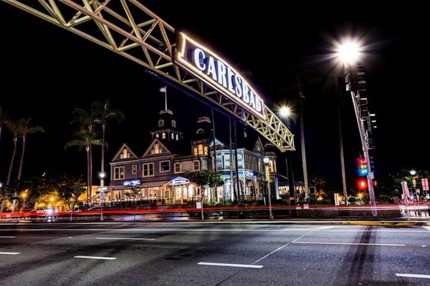 A historic building with a large illuminated sign reading 'CARISBAD' at night. 3