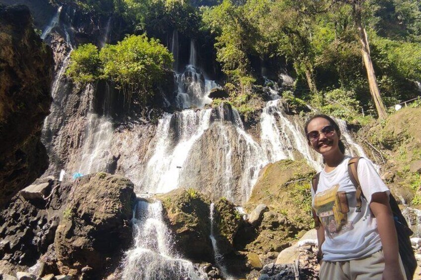 Une cascade composée de plusieurs ruisseaux, entourée d’un paysage rocheux et de verdure. 2