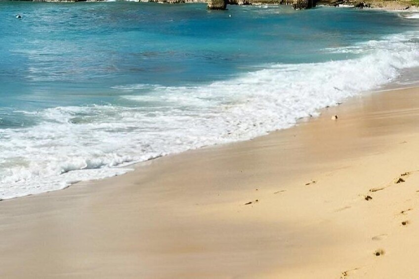 A sandy beach with gentle waves and a clear blue sea. 2