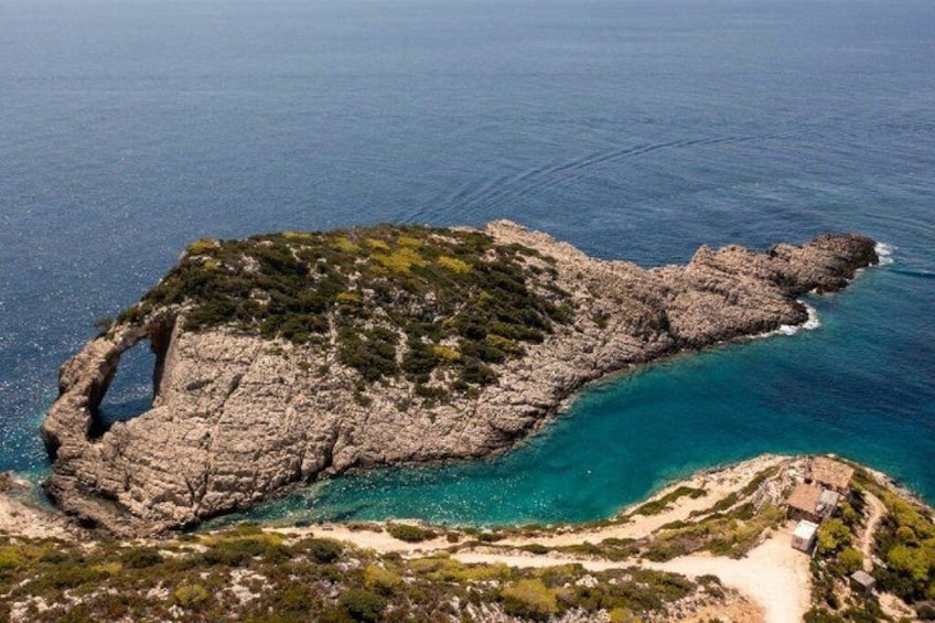 Una isla escarpada con una formación rocosa en arco natural rodeada de aguas turquesas. 5