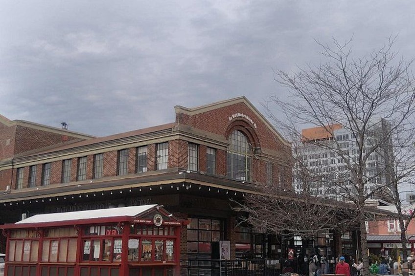 A historic brick building with a marquee and a covered outdoor seating area. 1