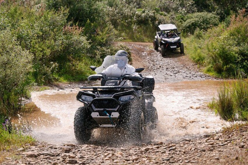 Twee offroad voertuigen rijden door een modderige beek. 2