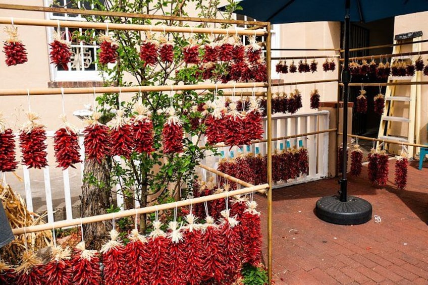 Una exhibición de chiles rojos sobre una rejilla metálica al aire libre. 2