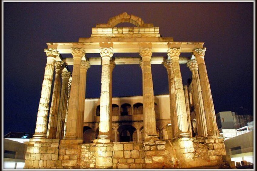 An ancient Greek temple with columns and a central pediment at night. 1
