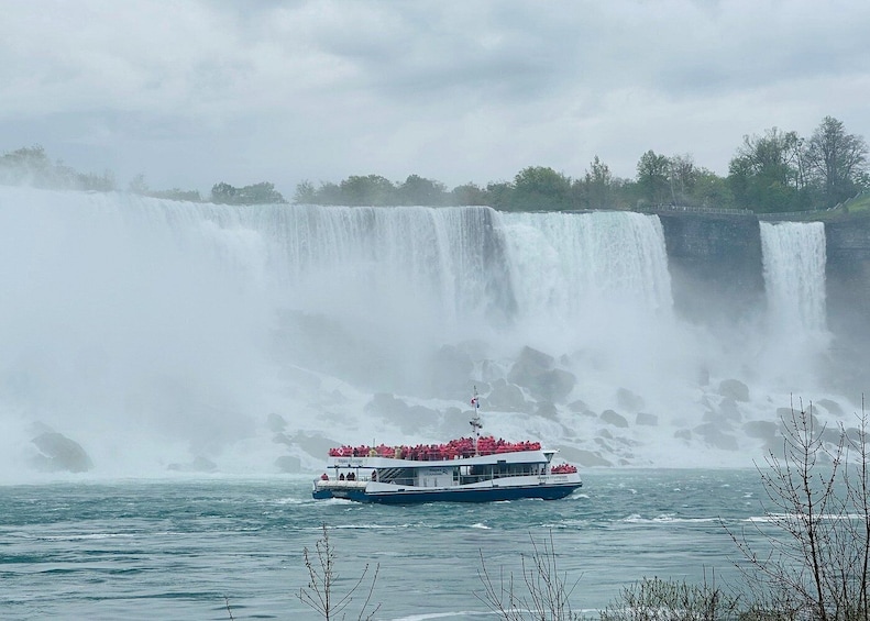 Un bateau transportant des passagers devant une grande cascade. 5