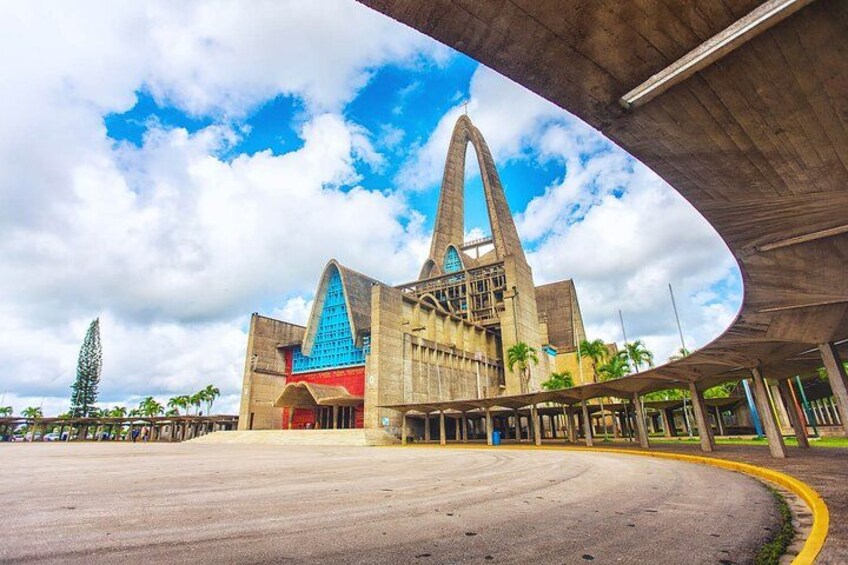 A large, modern building with a distinctive blue roof and a prominent central spire. 5