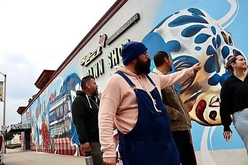 Un mural con un coche y una persona señalando. 3