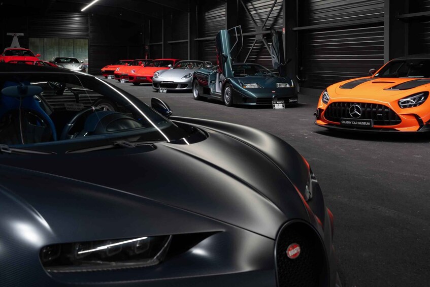 A collection of luxury sports cars in a dimly lit garage. 3