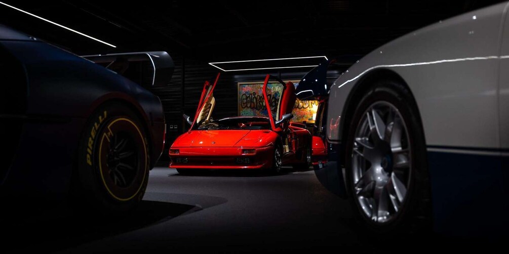 A red sports car in a dimly lit indoor space with arcade games in the background. 4